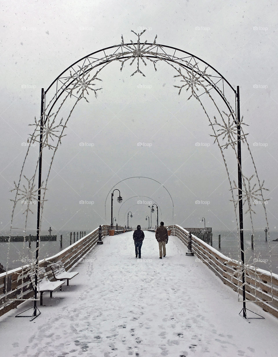 Walk along the pier during a snow storm 
