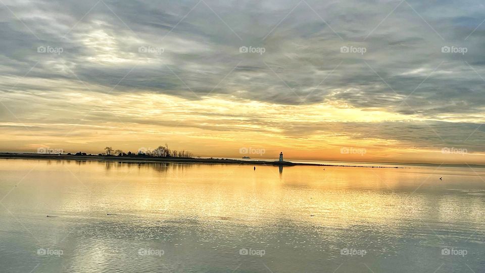 Sunrise with lighthouse and ferry in the distance 