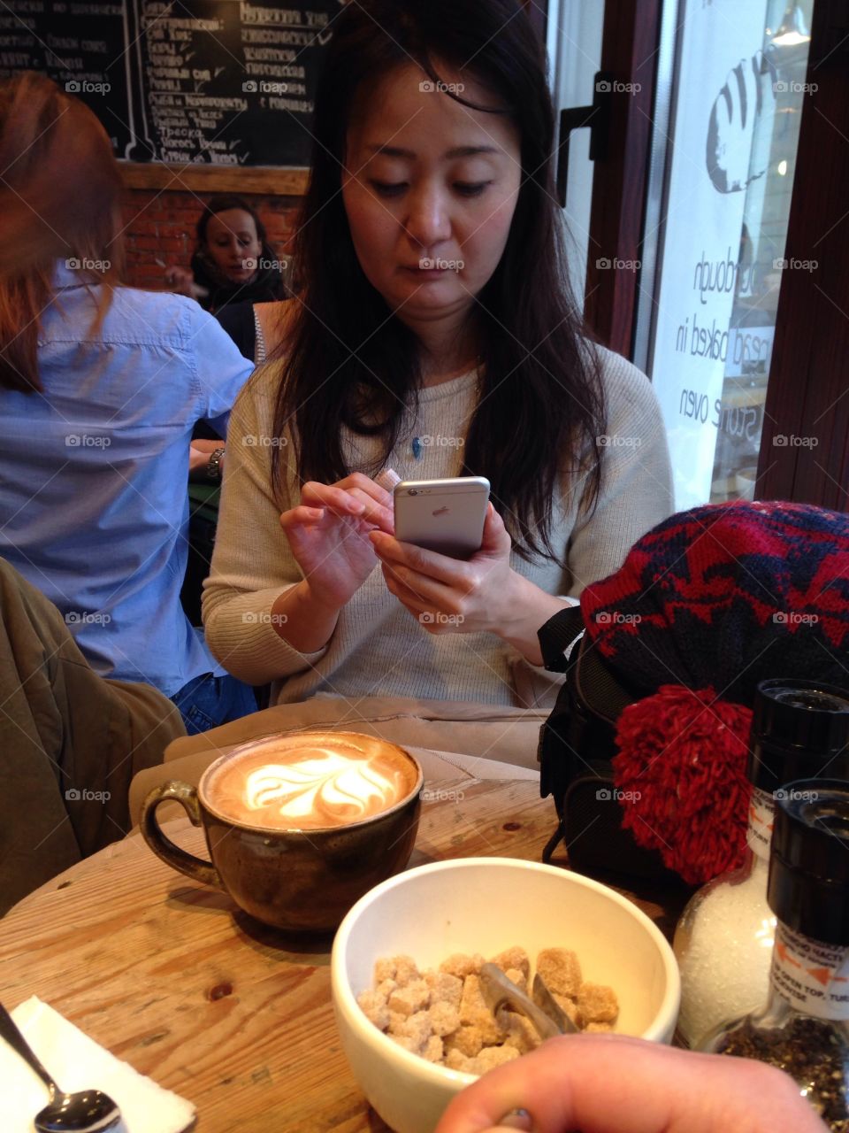 Girl with an iPhone in the cafe