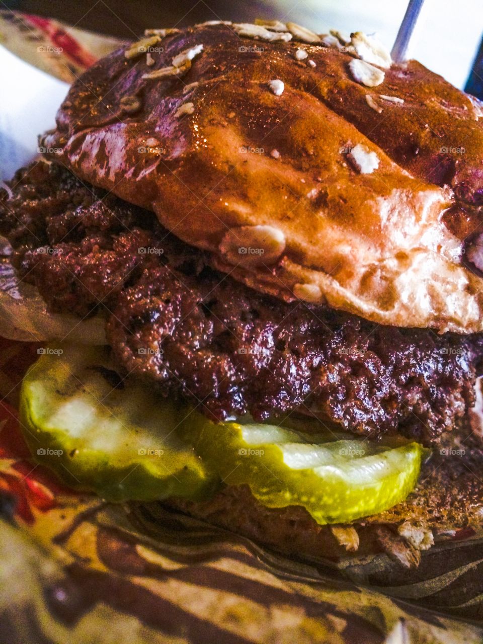 Juicy burger with pickles. Yum! Can't wait to take a bite. 