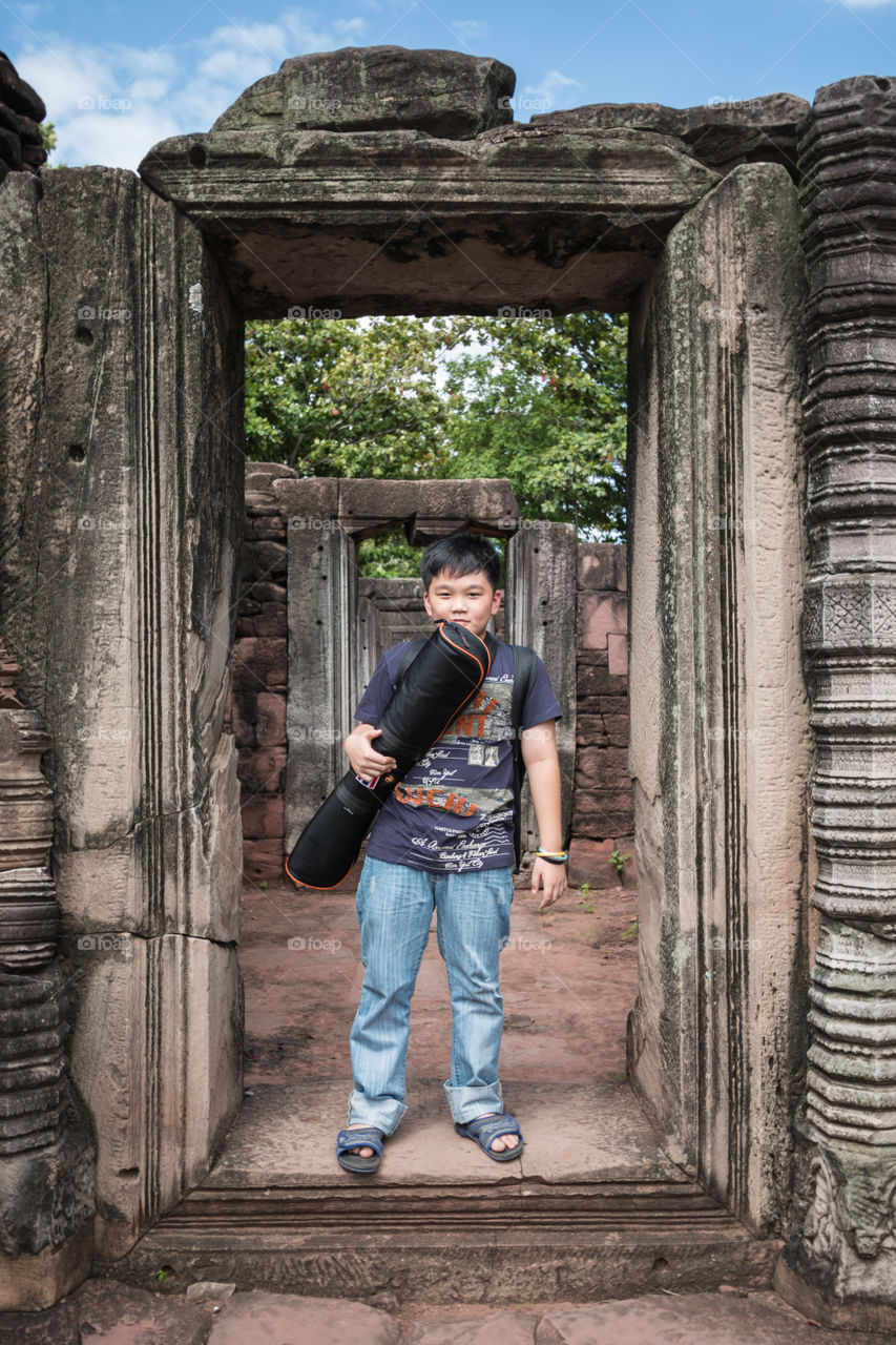 Boy with a bag in the old ruin temple