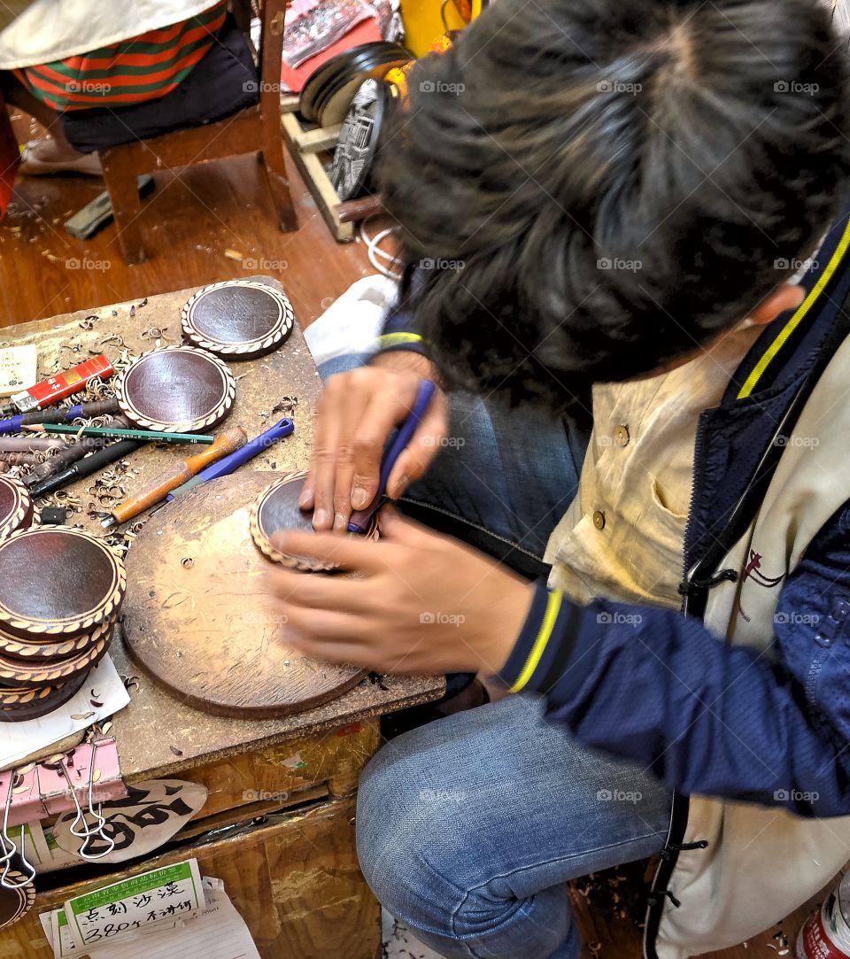 Wood carving artisan in the Old Town of Lijiang, Yunnan