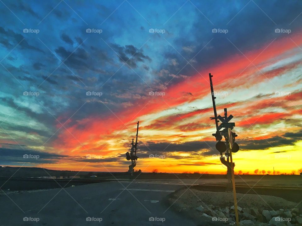 Empty rail cross road at sunset