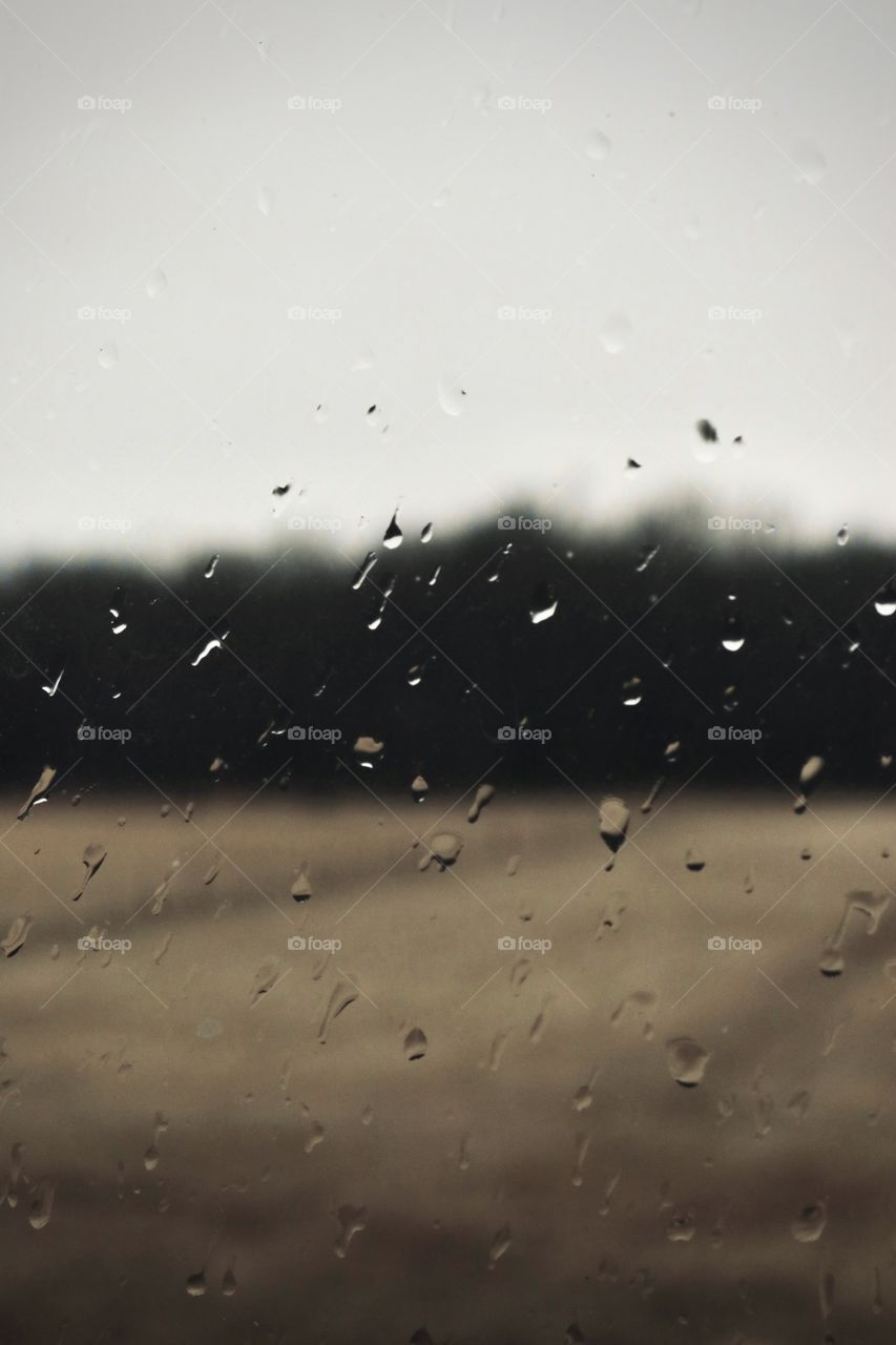 Winter in the county with a cold rain and drops on the window pane.