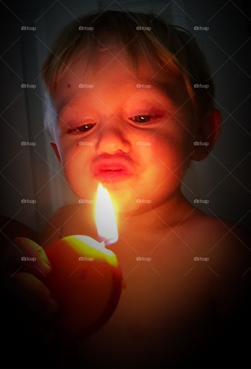 Little boy holding illuminated candle