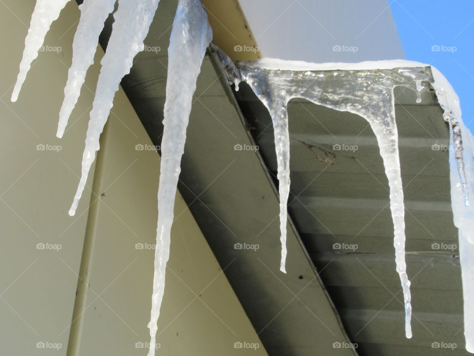 ice icicles on the cornice in the sun, harbingers of spring