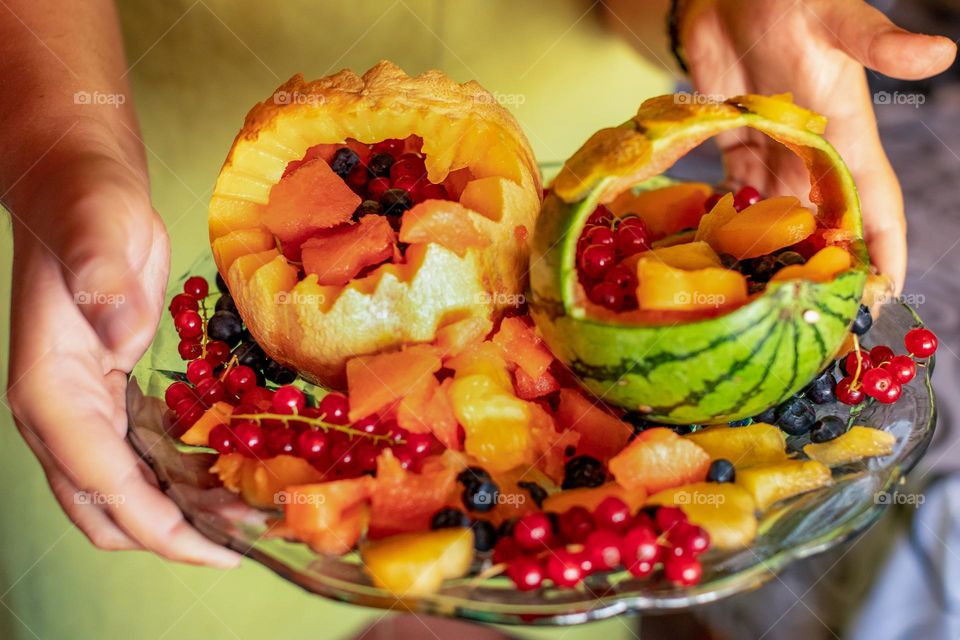 Fruit salad - carved fruit. Fruits: watermelon, cantaloupe, black and red currants