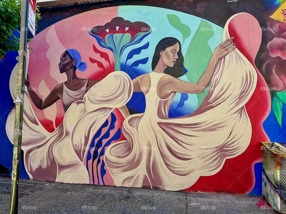 These Latina dancers are part of an art mural on „Jefferson Street“ off „Broadway“ and „Myrtle Avenue“ in „Bushwick“, Brooklyn that spans almost an entire city block. It is next to „La Lupe“, a popular club restaurant. 2024. Hypnotic Productions