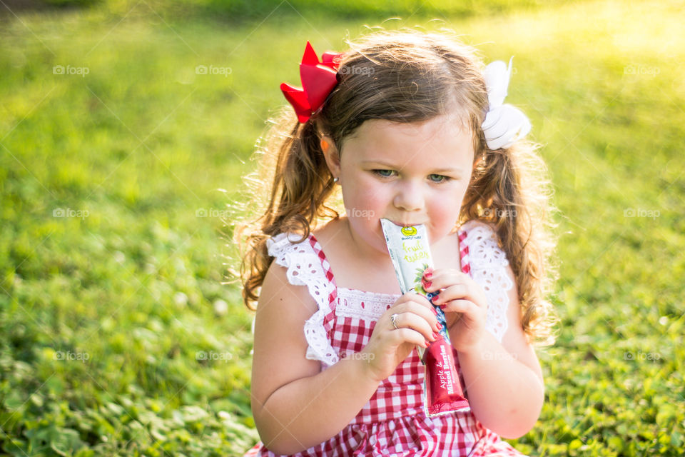 Young Girl in red and White Dress Eating Buddy Fruit Tube 2