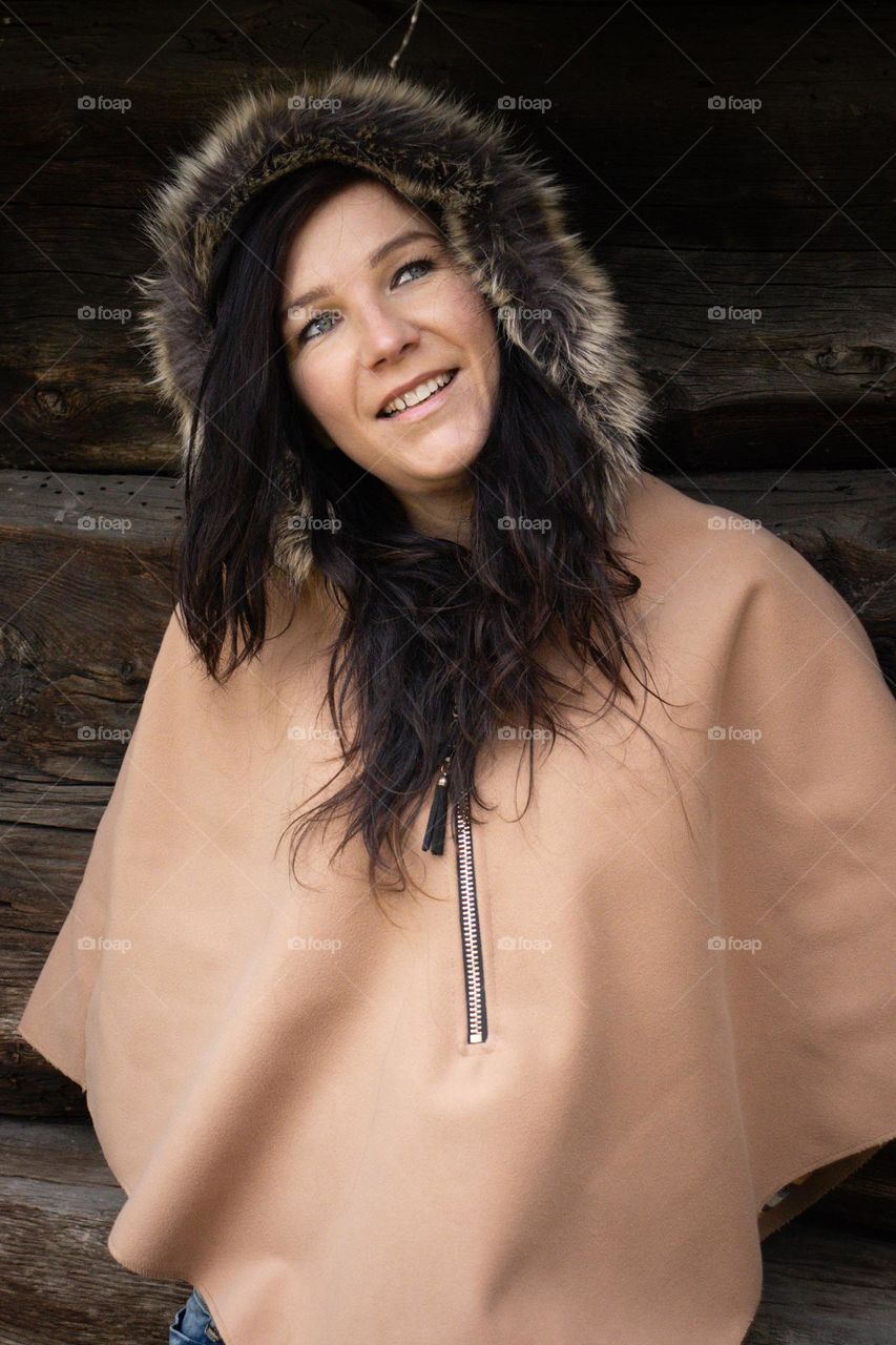 Smiling beautiful woman in the 30s .
She is happy and smiling . Wearing a hoodie for the wind .