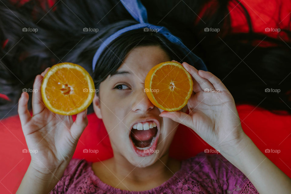 Funny photo of a girl holding oranges