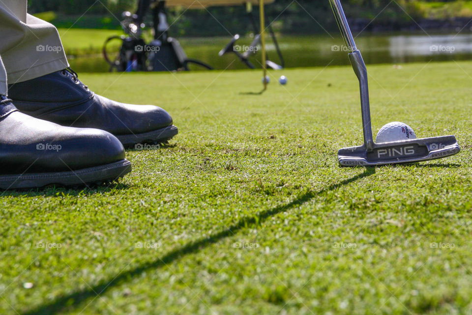 A golfer puts a ball towards the hole