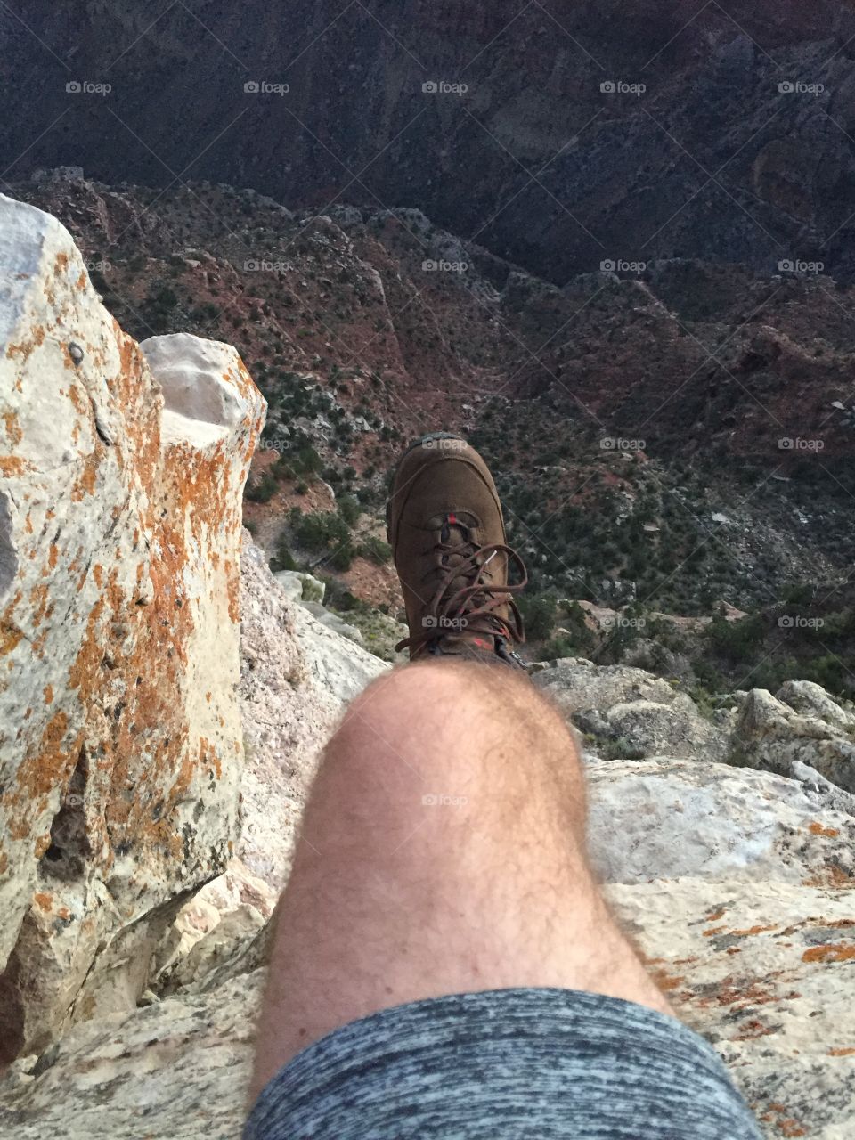 My leg dangles over a cliff at the Grand Canyon before a hike around the southern rim. 