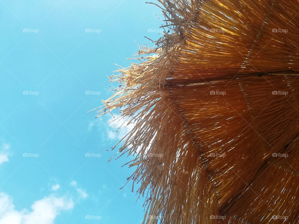 Straw beach umbrella and sky