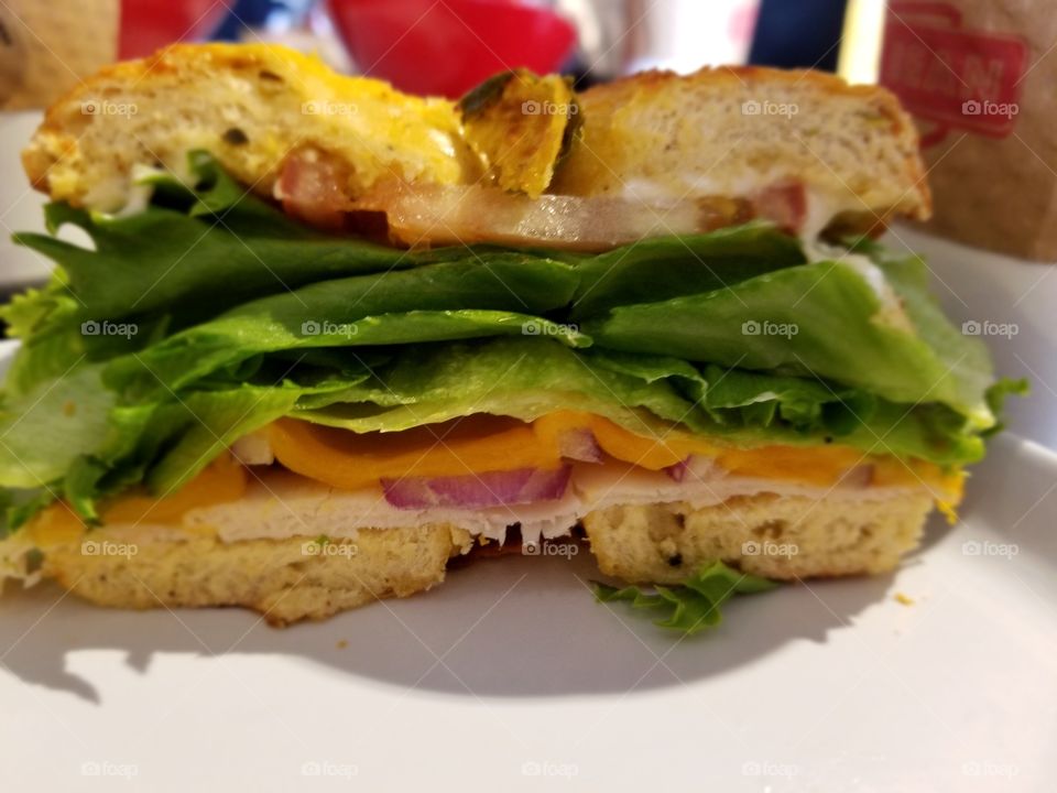 bagel with lettuce and bacon and cheese and ham