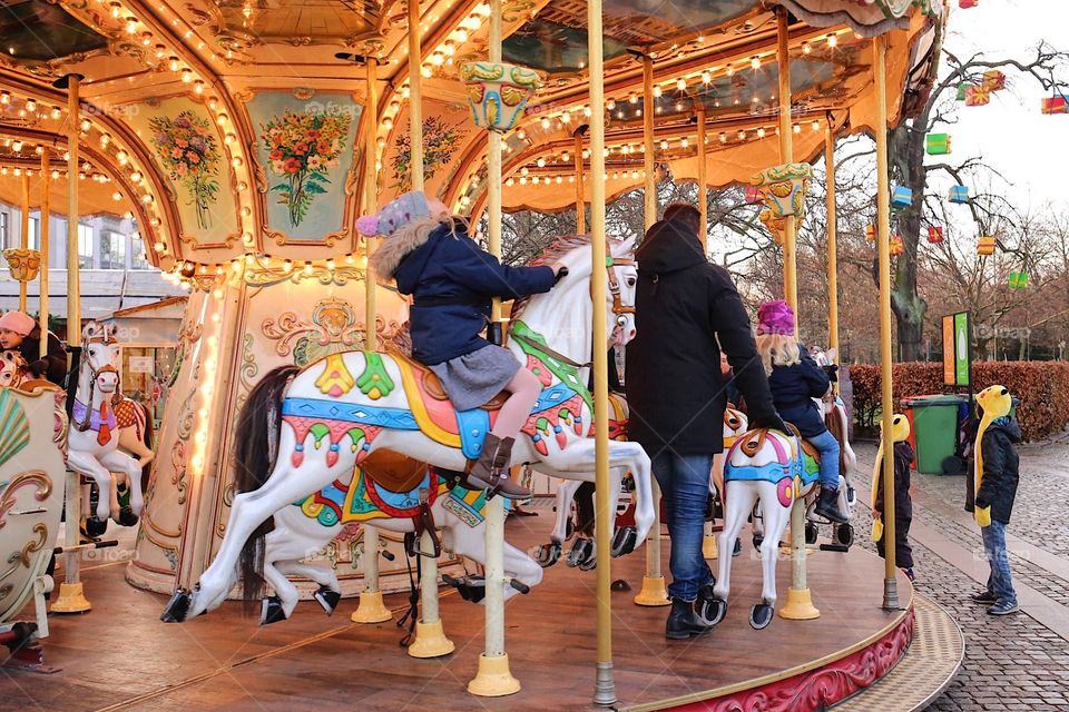 Kids and families having fun on an oldfashion carousel in winter time 