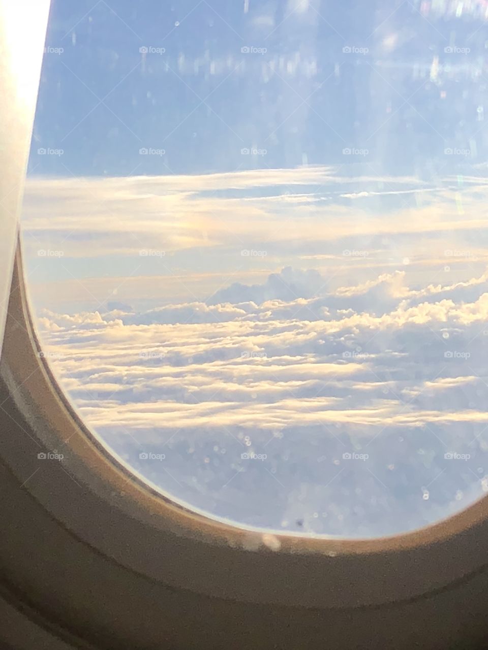 A picture of the morning clouds and sun taken from the window of an airplane! 