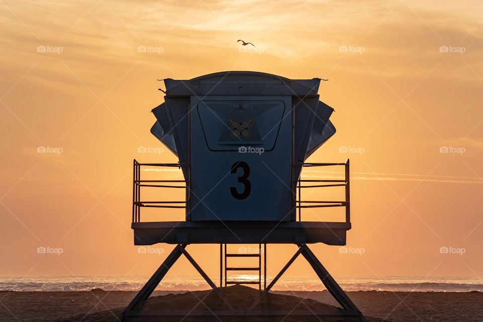 Silhouette of a lifeguard tower at Pismo Beach, California as the sun sets. 