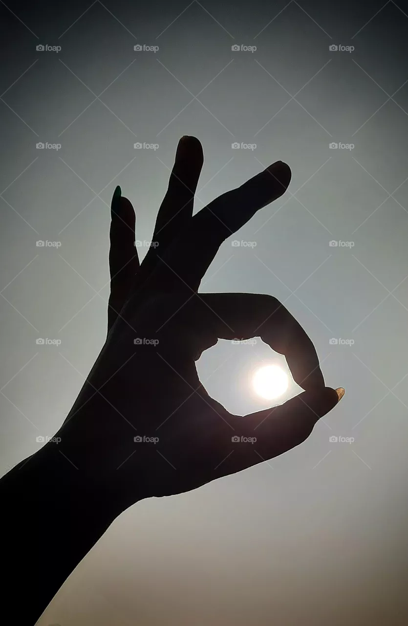 In this photo I captured hand and sun. I captured a black and white photo by reflection of sun , without filter, reflection of sun