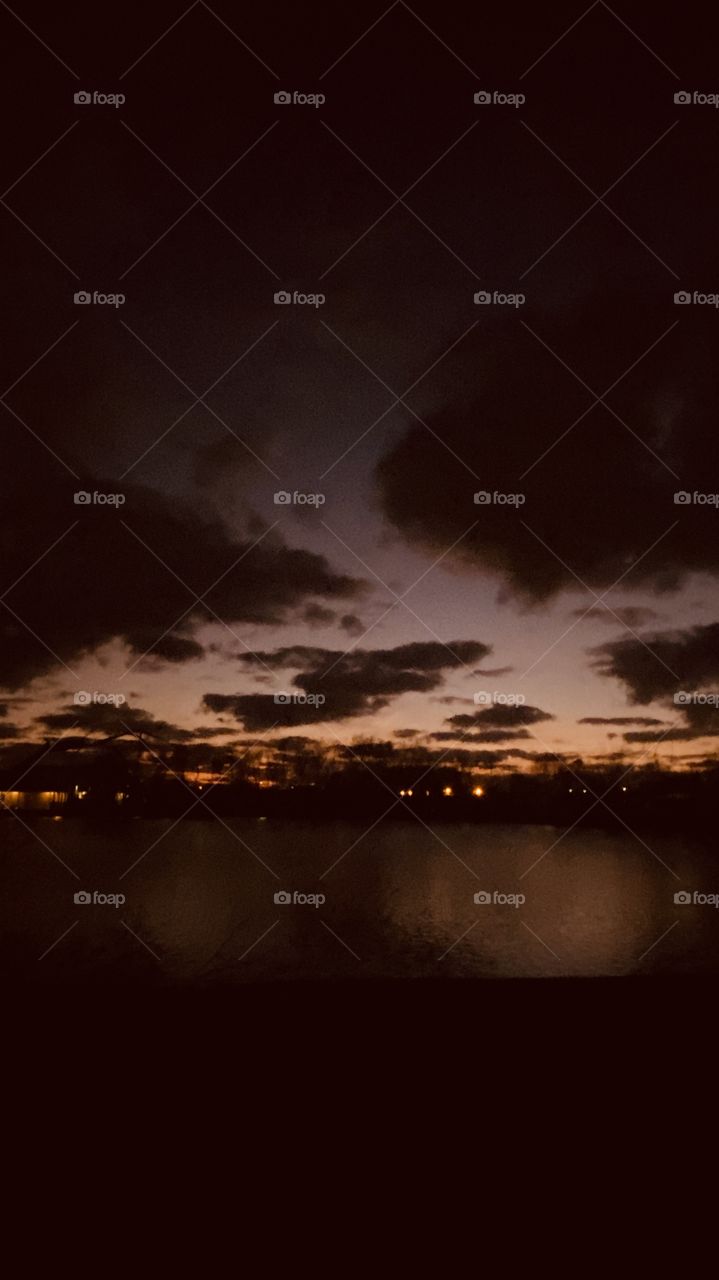 Evening sunset Reflective silhouette on Lake Water with Evening Colors timing for Sunset. Mostly Cloudy Heavy Clouds building for Strong Weather Front Headed to this Region.