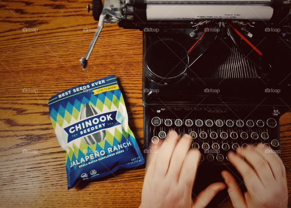 Man Typing with Sunflower Seeds View From Above