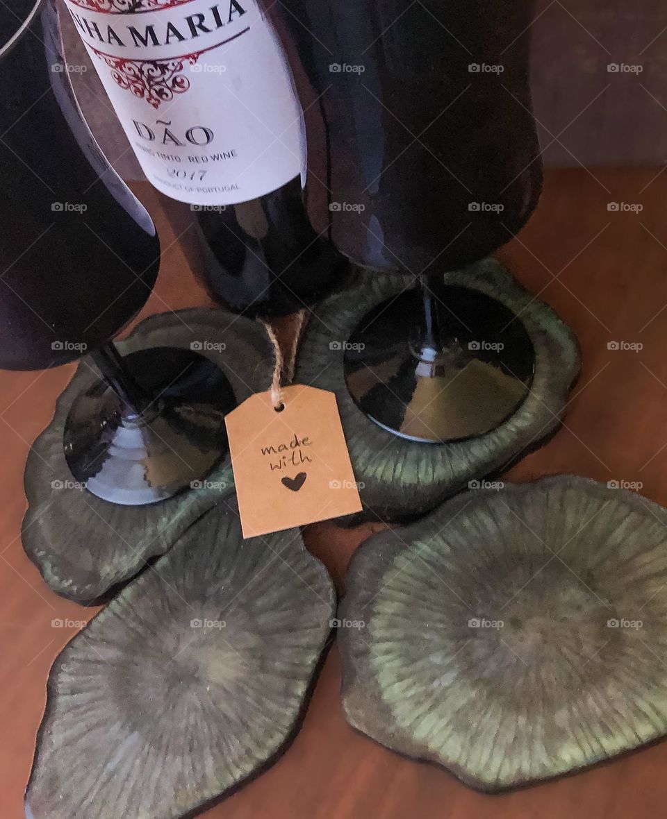 Resin geode shaped coasters that I made, displayed with black wine glasses and a bottle of wine.