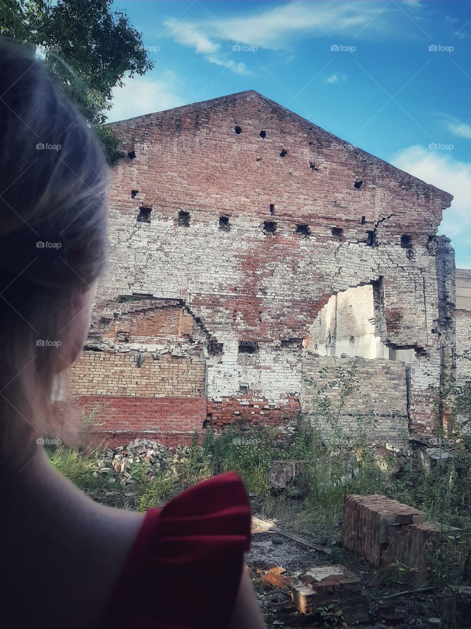 девушка смотрит на разрушенное здание