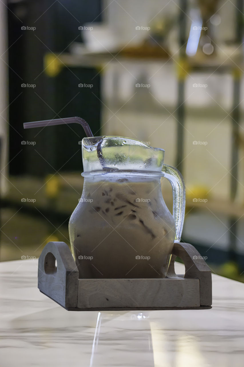 Iced coffee put whipped cream in a glass on the table.