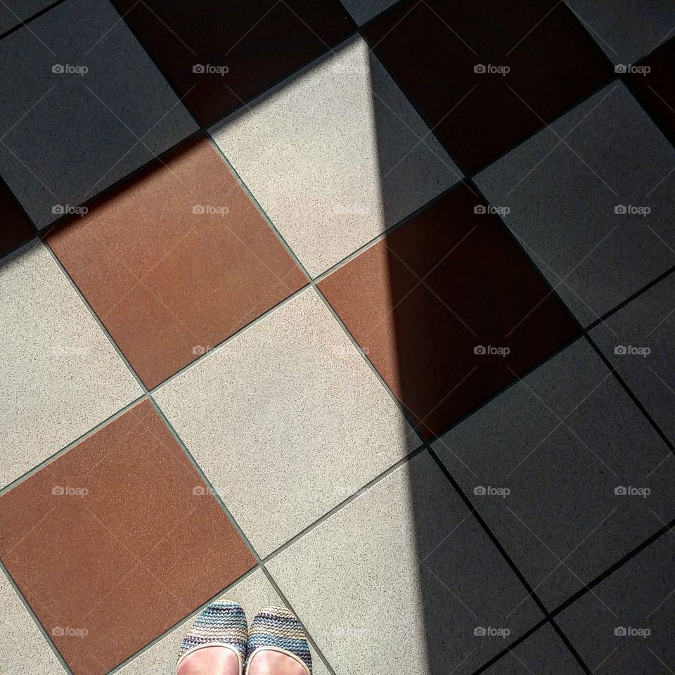Shadow play on the tiled floor in office building