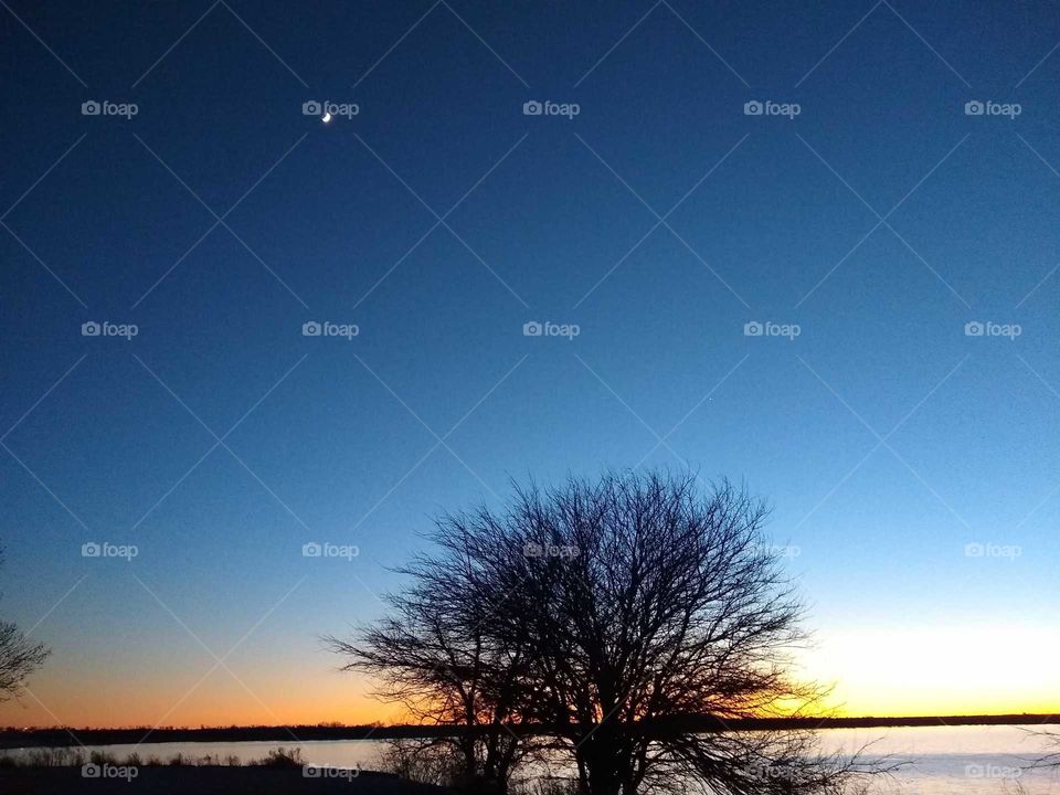 Beautiful golden blue sunset over lake with crescent moon. "Shining Bright".