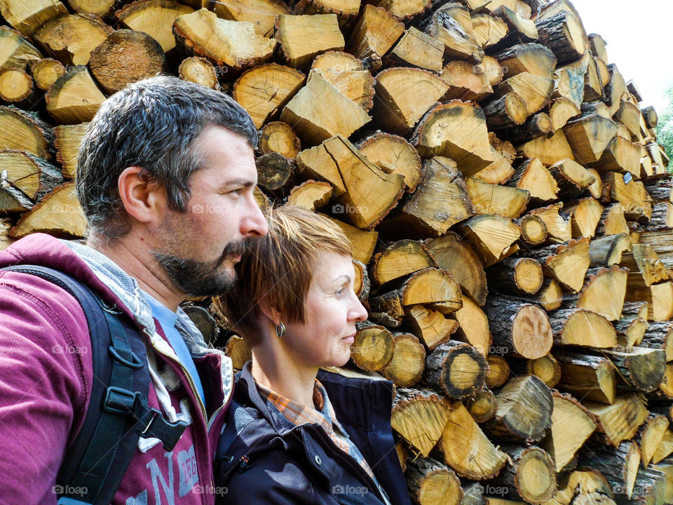 man and girl on the background of firewood