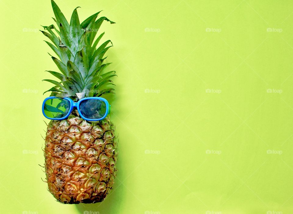 Pineapple Wearing Blue Sunglasses On Lime Background 