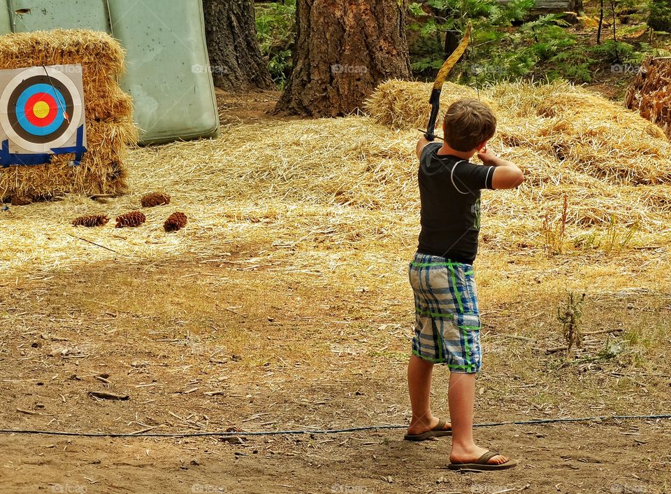 Archery Range. Boy Shooting Arrows At A Forest Archery Range
