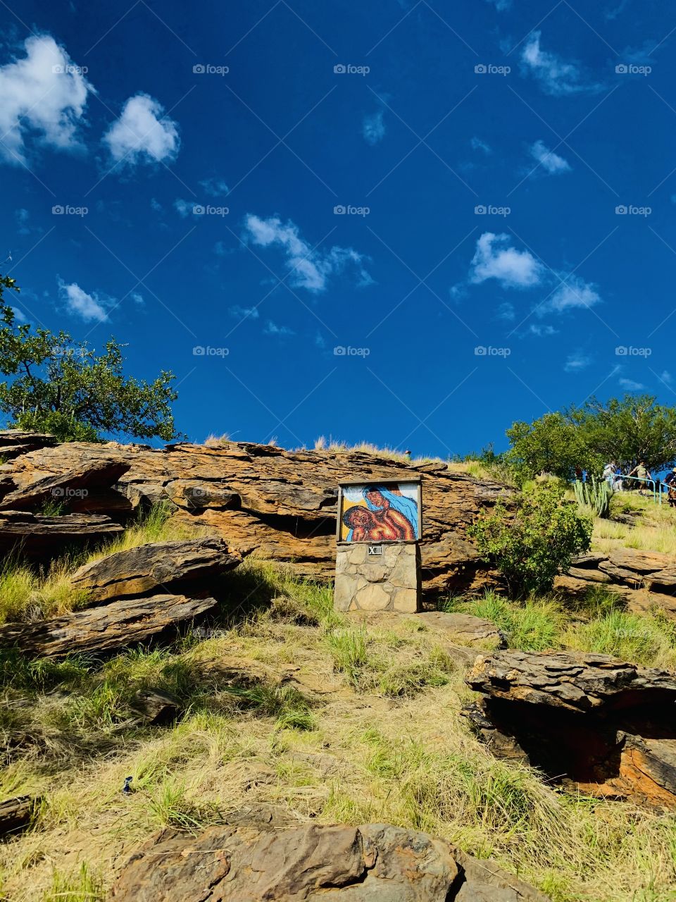 Rock crafted painting on a stone up a mountain in a rocky area. With a beautiful blue sky.