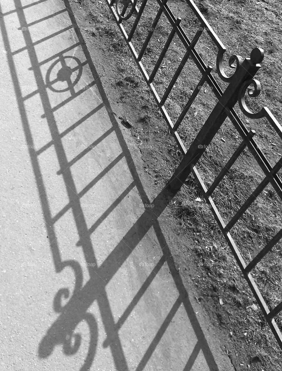 Fence shadow. Patterns on the asphalt.