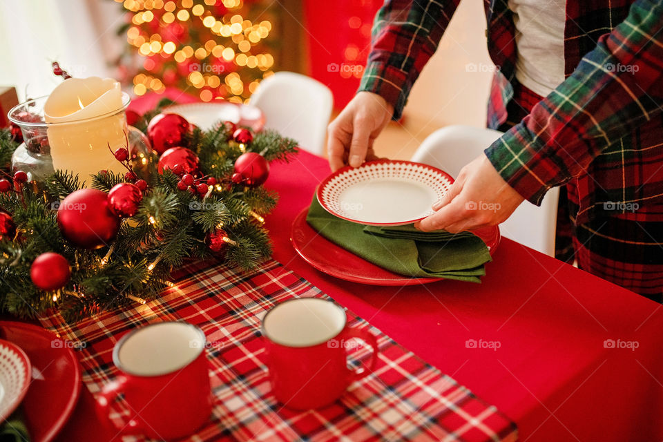 man sets a beautiful decorated winter table for a festive dinner.  Merry Christmas and Happy New Year.