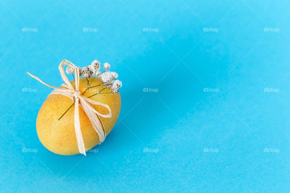 Yellow Easter egg on blue background