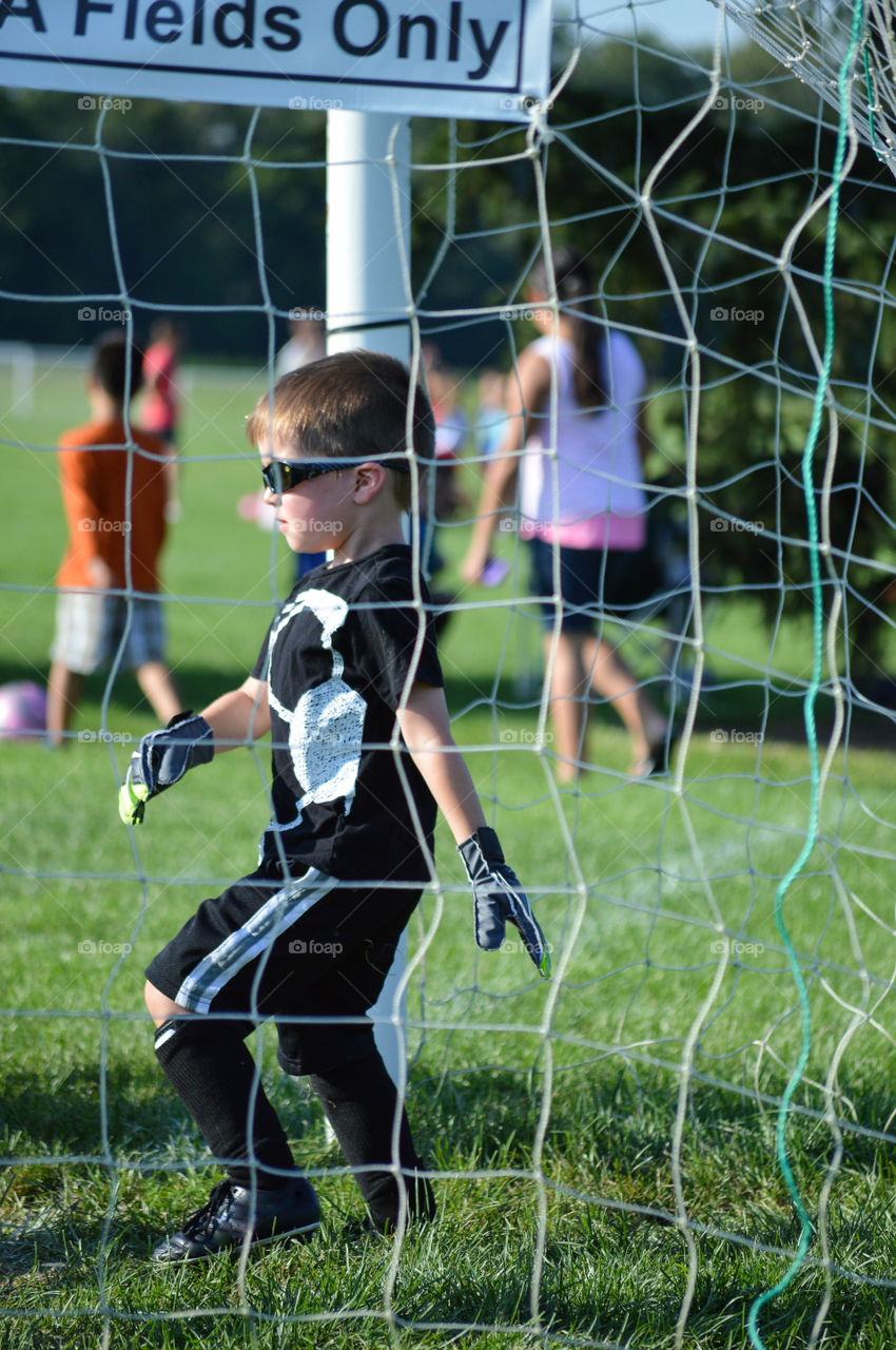 Young boy playing soccer as a goalie