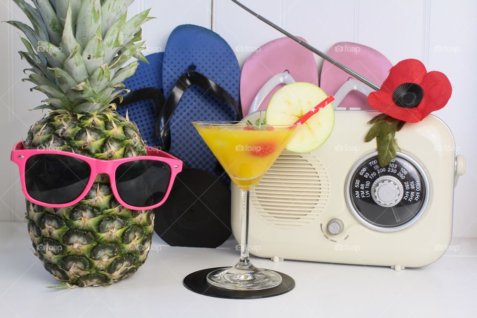 Beach party! Fruit with funny eyes and glasses next a vintage radio and flip flops 