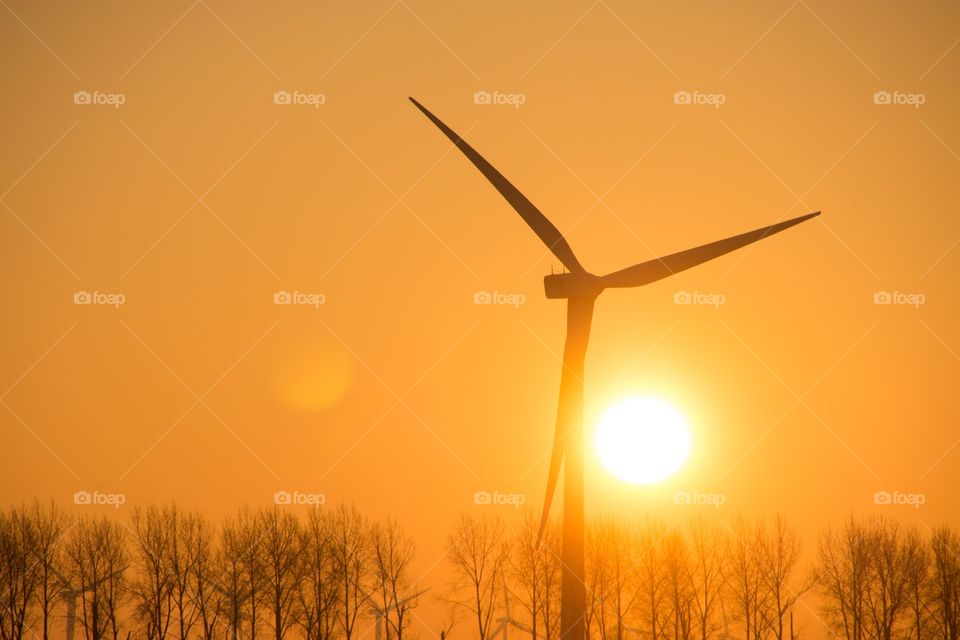 Sunrise early in the morning next to a windmill
