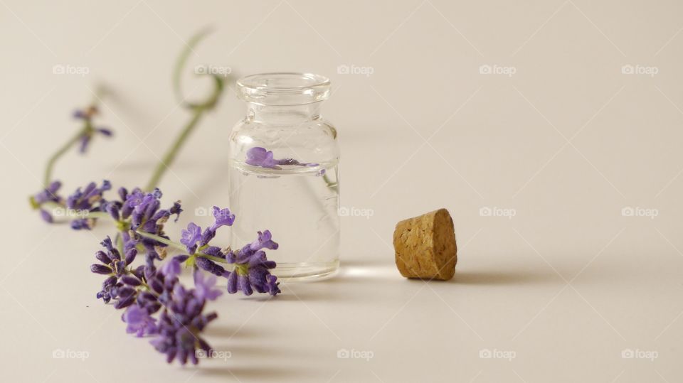 Glass jar with oil and lavender flowers