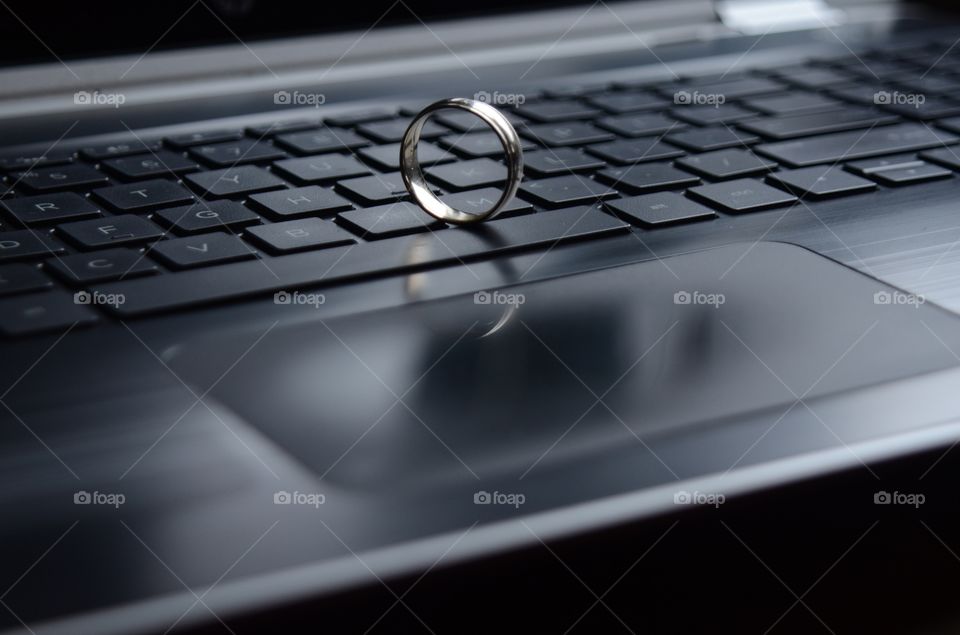 A gold ring appears on the keyboard of a laptop computer.