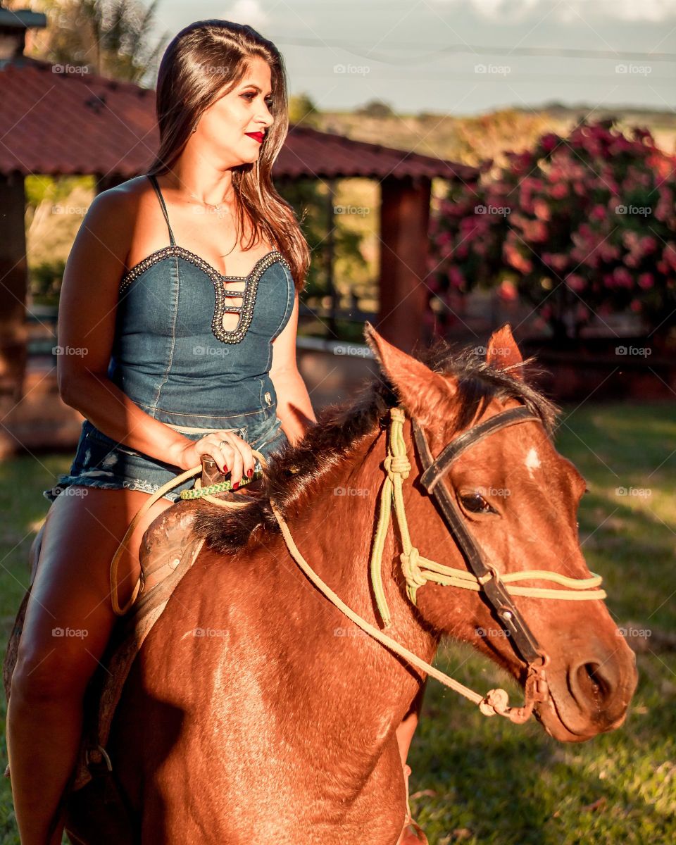 woman on top of horse on farm