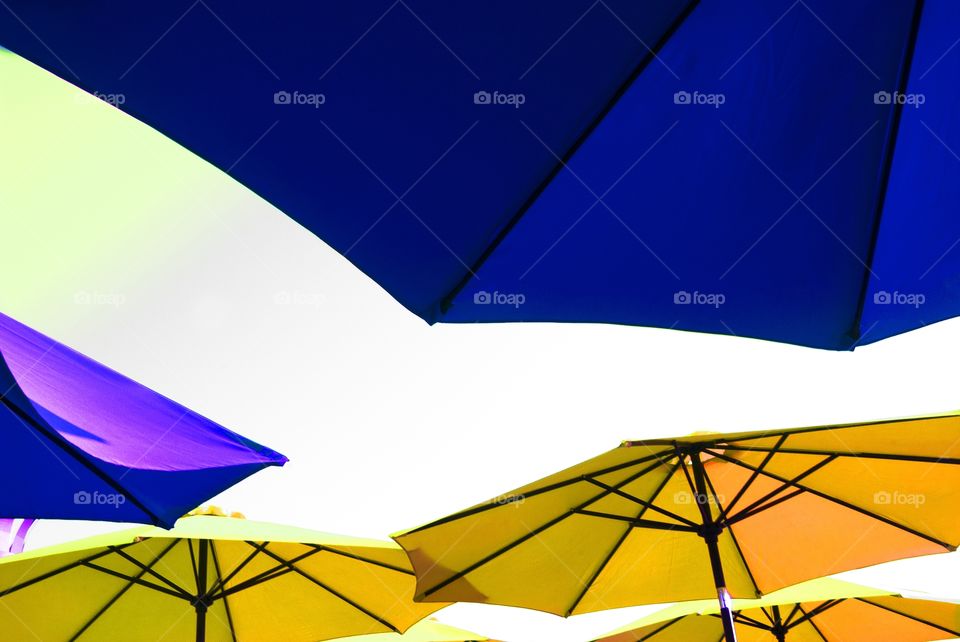 A color assorted group of umbrellas provide the shade on a party boat.