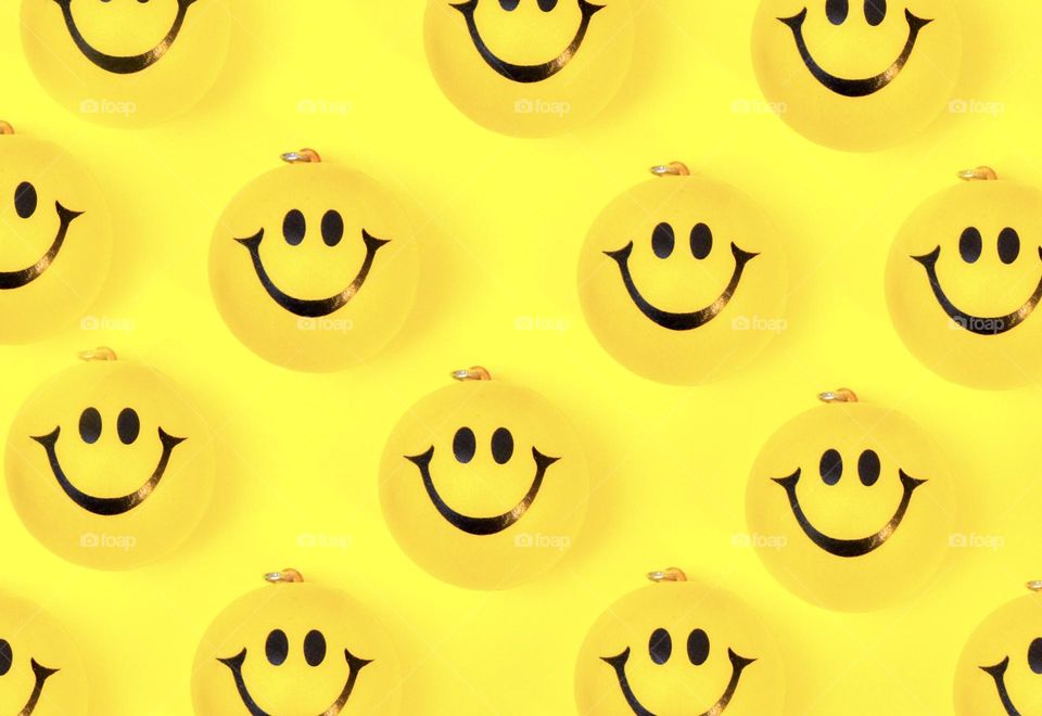 Yellow smileys on yellow background 