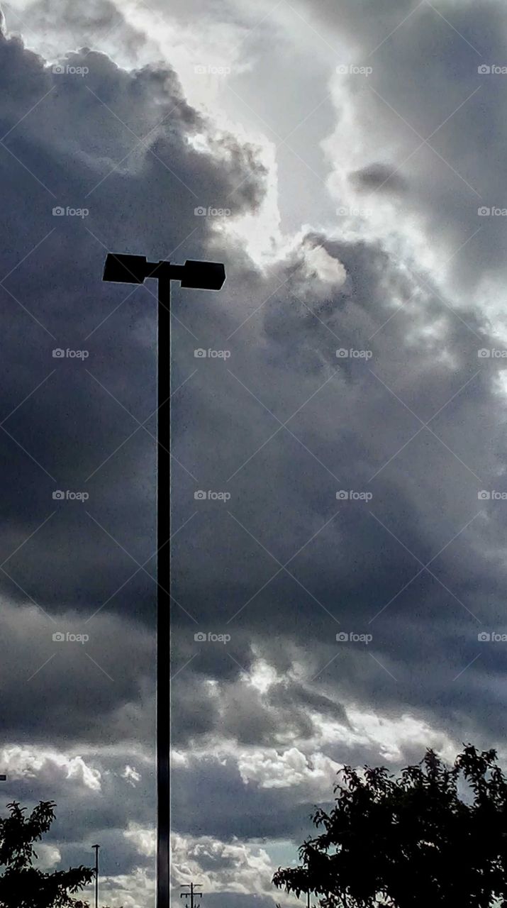 dark gray ominous clouds and a light post
