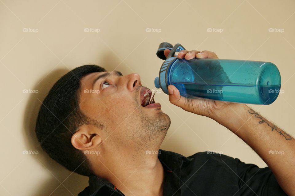 young man drinking water from bottle