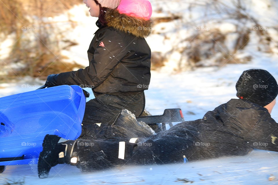 Children playing and crashing with their sleds