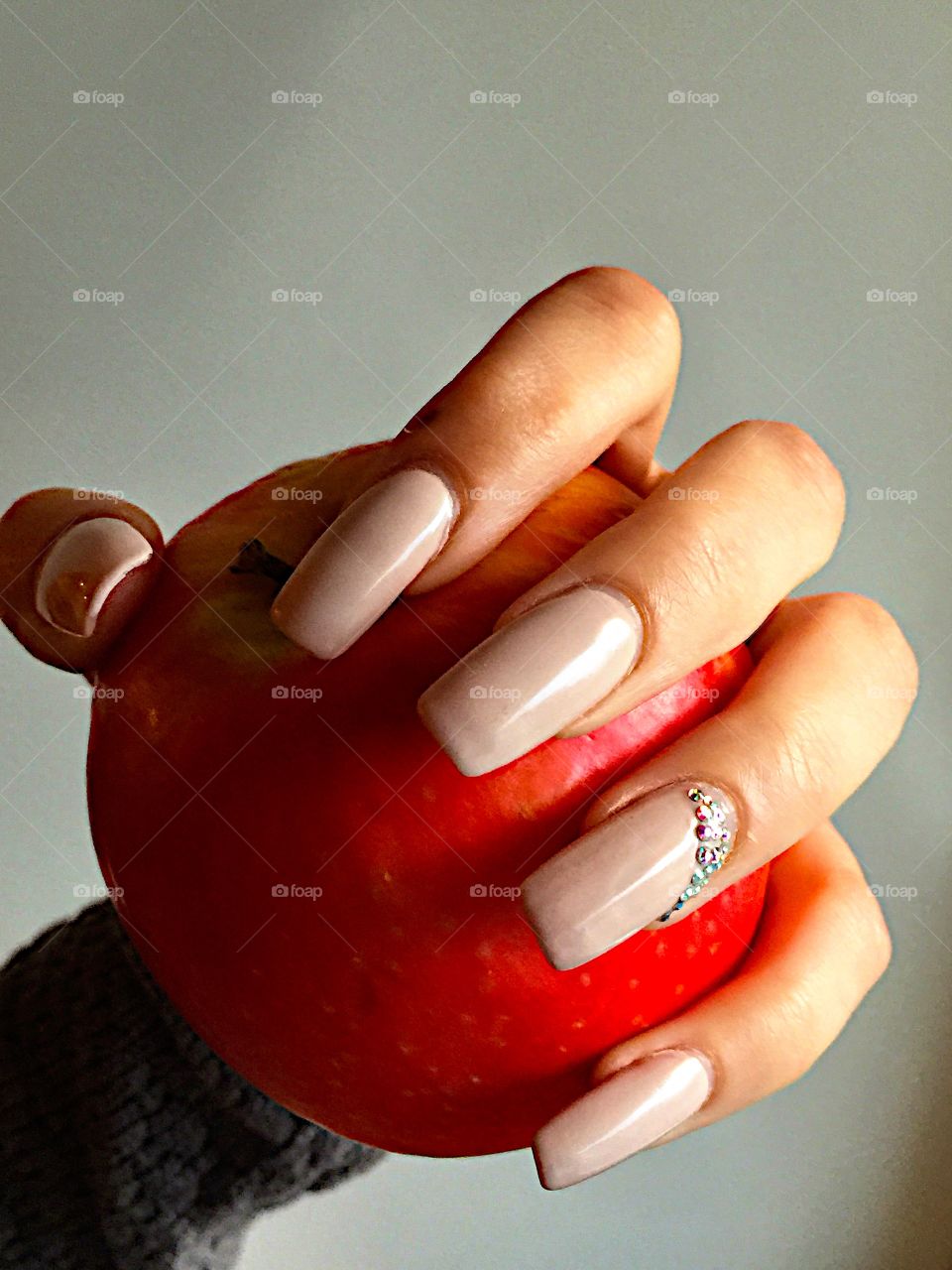 Long beige nails and the hand holding a red apple! 