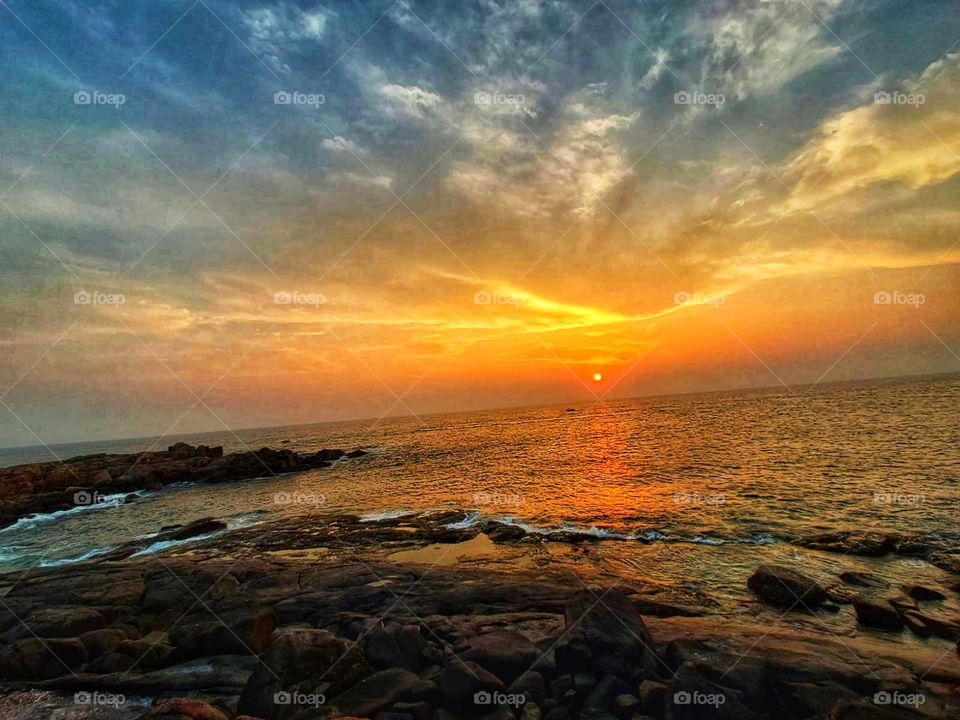 That sunset on the ocean with the rocks is absolutely breathtaking! It's like nature painting a masterpiece in the sky. 🌅🌊